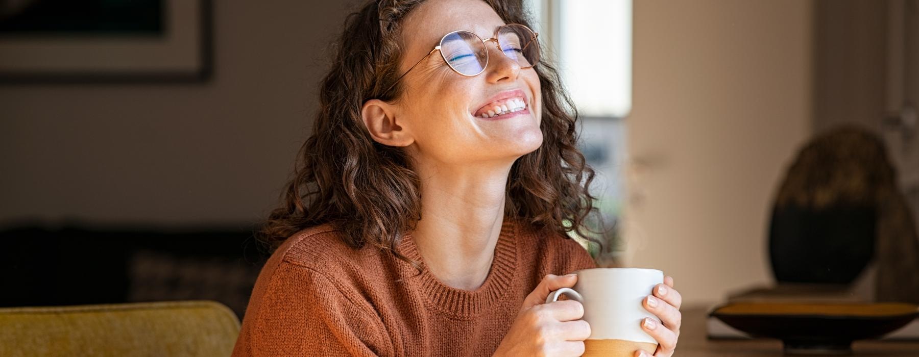 a woman wearing glasses and holding a cup