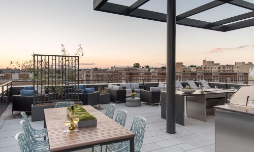 a patio with a table and chairs and a view of a city